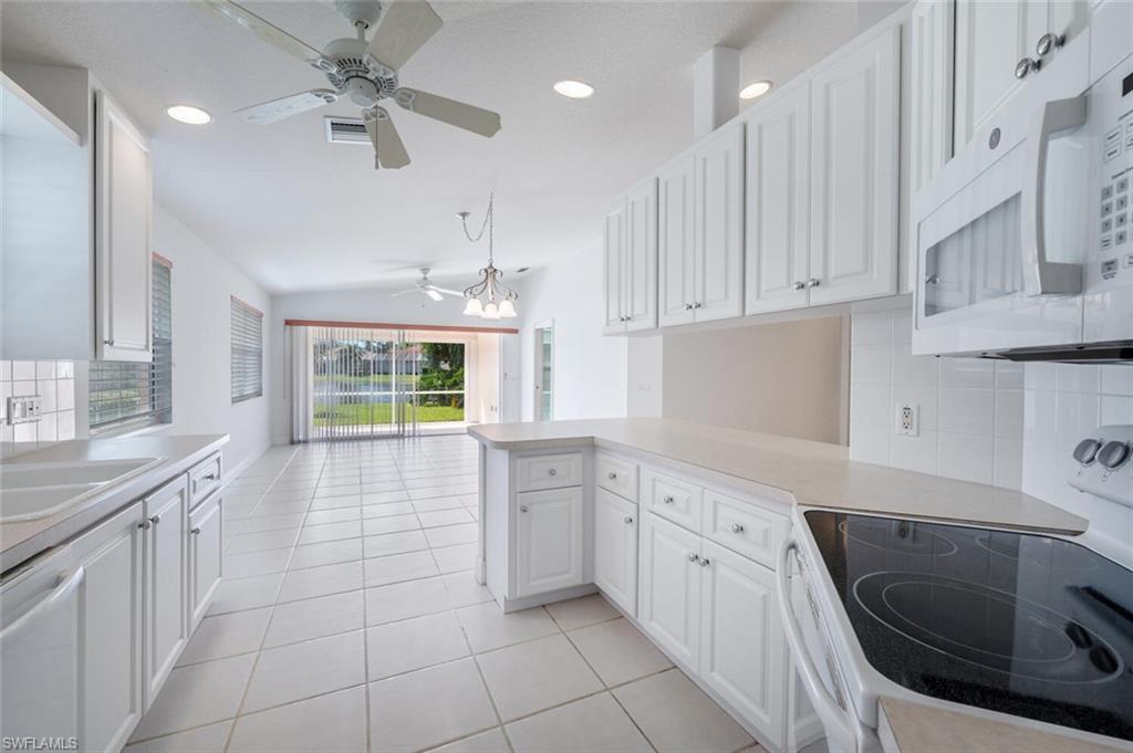 4231 Redonda Lane Naples, FL 34119 - Photo 6 of 28 a kitchen with a stove sink and cabinets