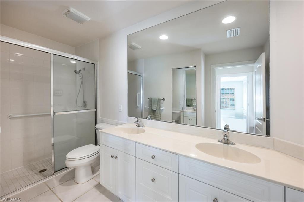 4231 Redonda Lane Naples, FL 34119 - Photo 10 of 28 a bathroom with a double vanity sink toilet mirror and shower
