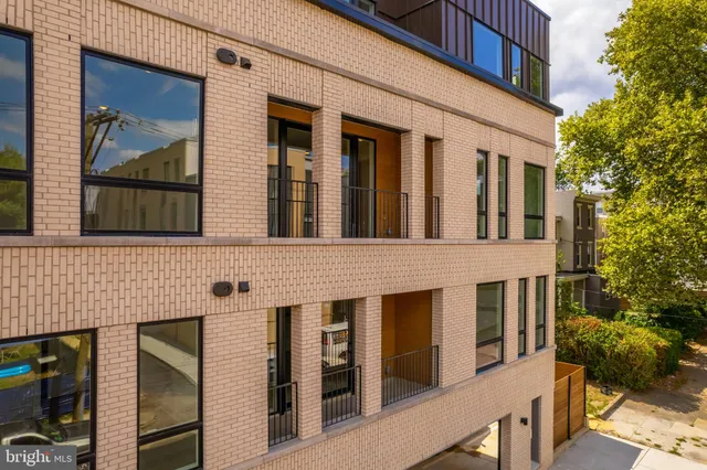 a front view of a building with a tree