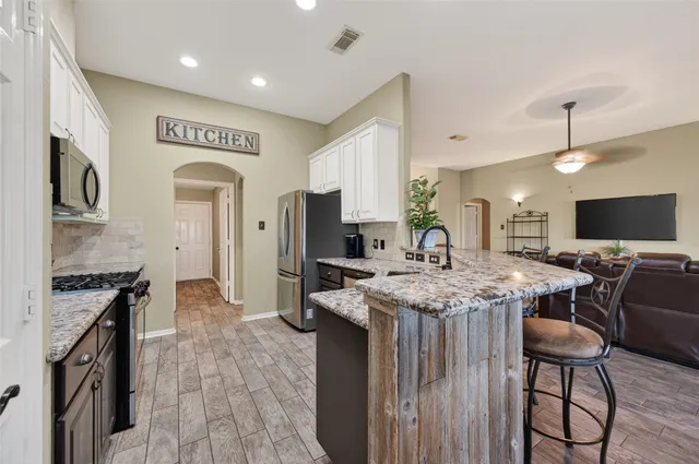 a kitchen with stainless steel appliances granite countertop counter space a sink refrigerator and cabinets