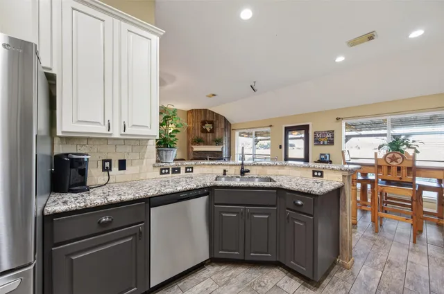 a kitchen with granite countertop a sink and cabinets