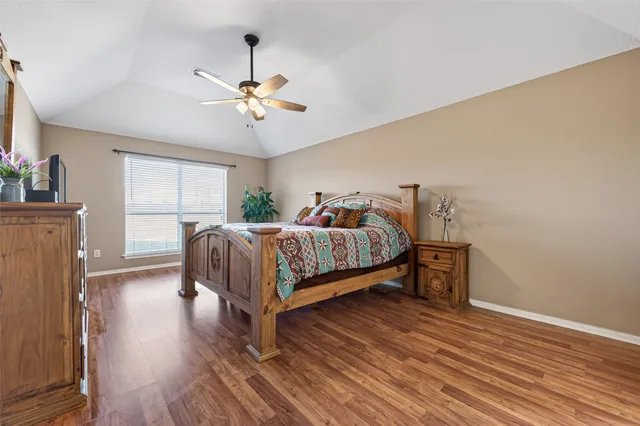 a bedroom with a bed chandelier and a window