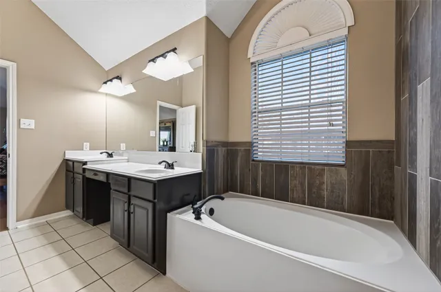a bathroom with a tub sink and mirror