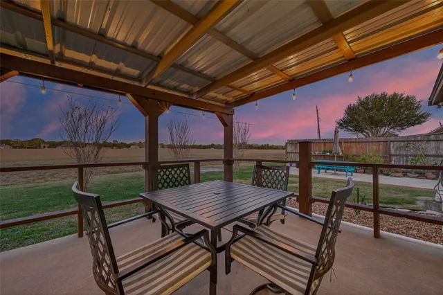 a view of a roof deck with table and chairs with wooden floor