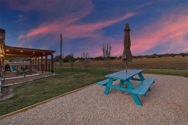 a park view with a bench under an umbrella