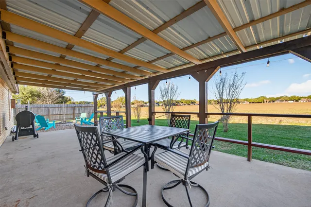 a view of a patio with table and chairs