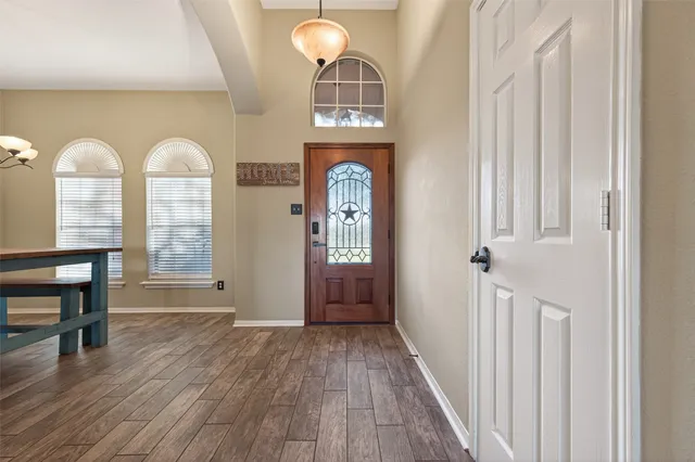 a view of a hallway with wooden floor windows and entryway