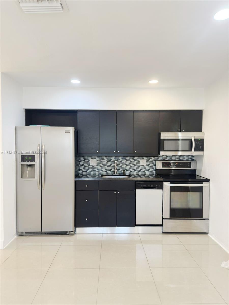 317 Hendricks Isle, Unit 1 Fort Lauderdale, FL 33301 - Photo 4 of 15 a kitchen with stainless steel appliances granite countertop a refrigerator and a stove