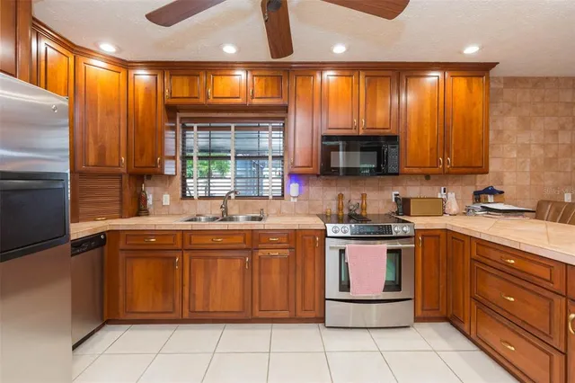 a kitchen with stainless steel appliances granite countertop wooden cabinets a sink and a stove