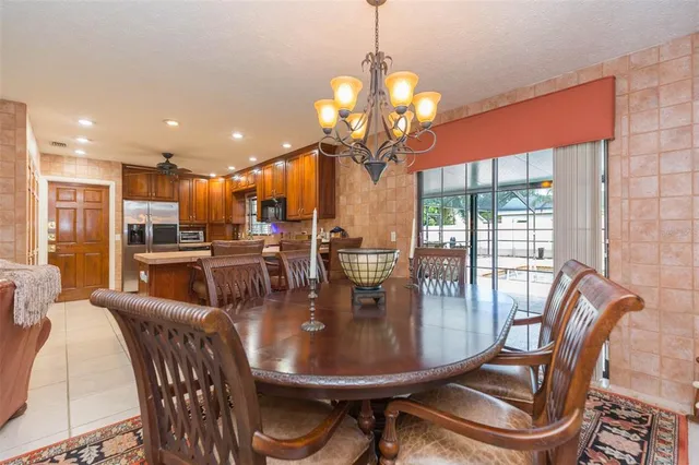 a dining room with furniture a chandelier and wooden floor