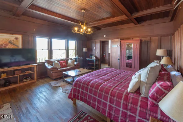 a bedroom with a bed and dresser with mirror