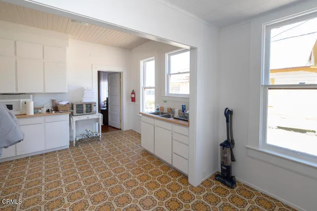 a room with stainless steel appliances kitchen island granite countertop a table chairs and a refrigerator