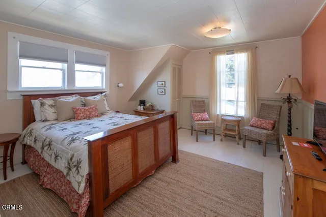a view of potted plants and a tree in front of a house