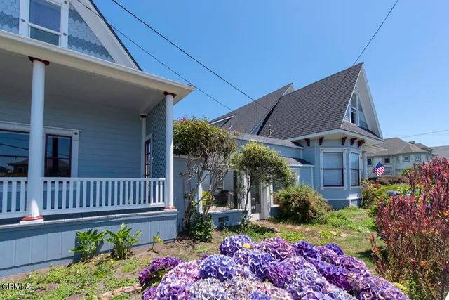 a view of a house with a yard and potted plants