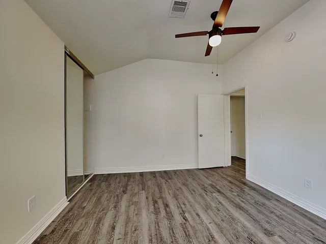 a view of room with hardwood floor and a ceiling fan