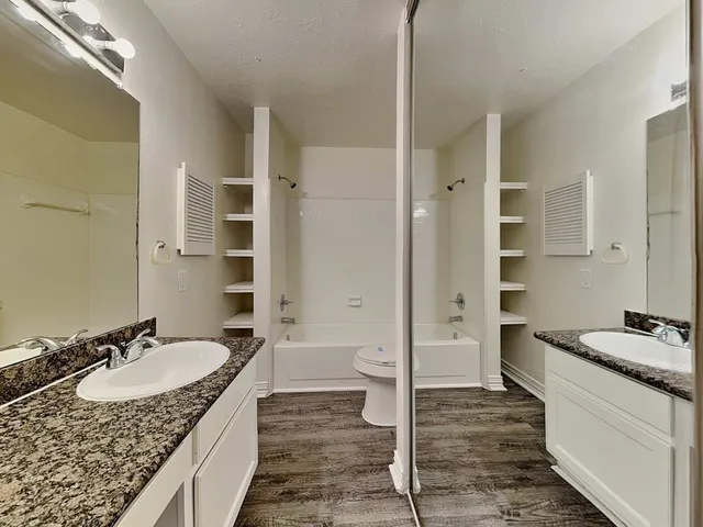 a spacious bathroom with a granite countertop sink and a mirror