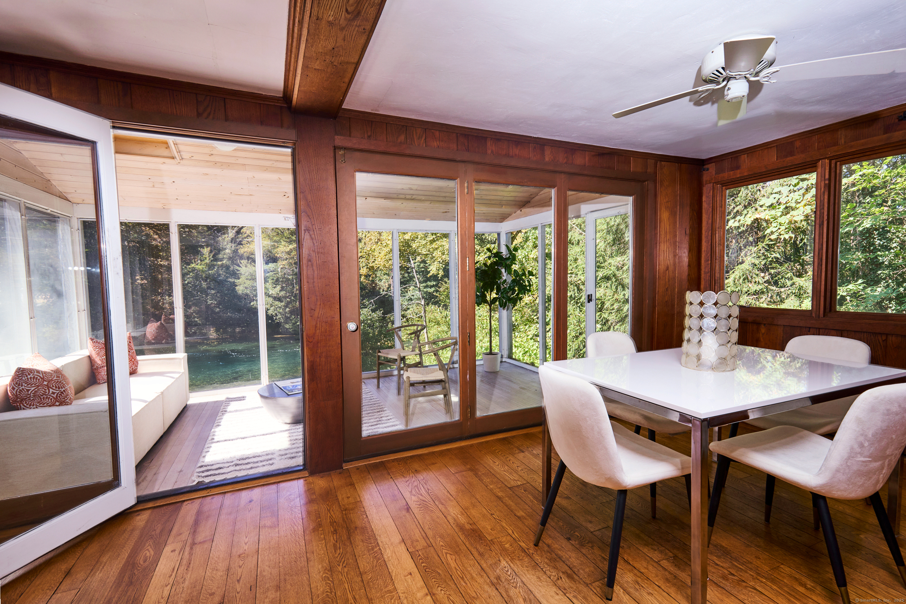 136 Lyons Plain Road Weston, CT 06883 - Photo 11 of 31 a view of a dining room with furniture large windows and wooden floor