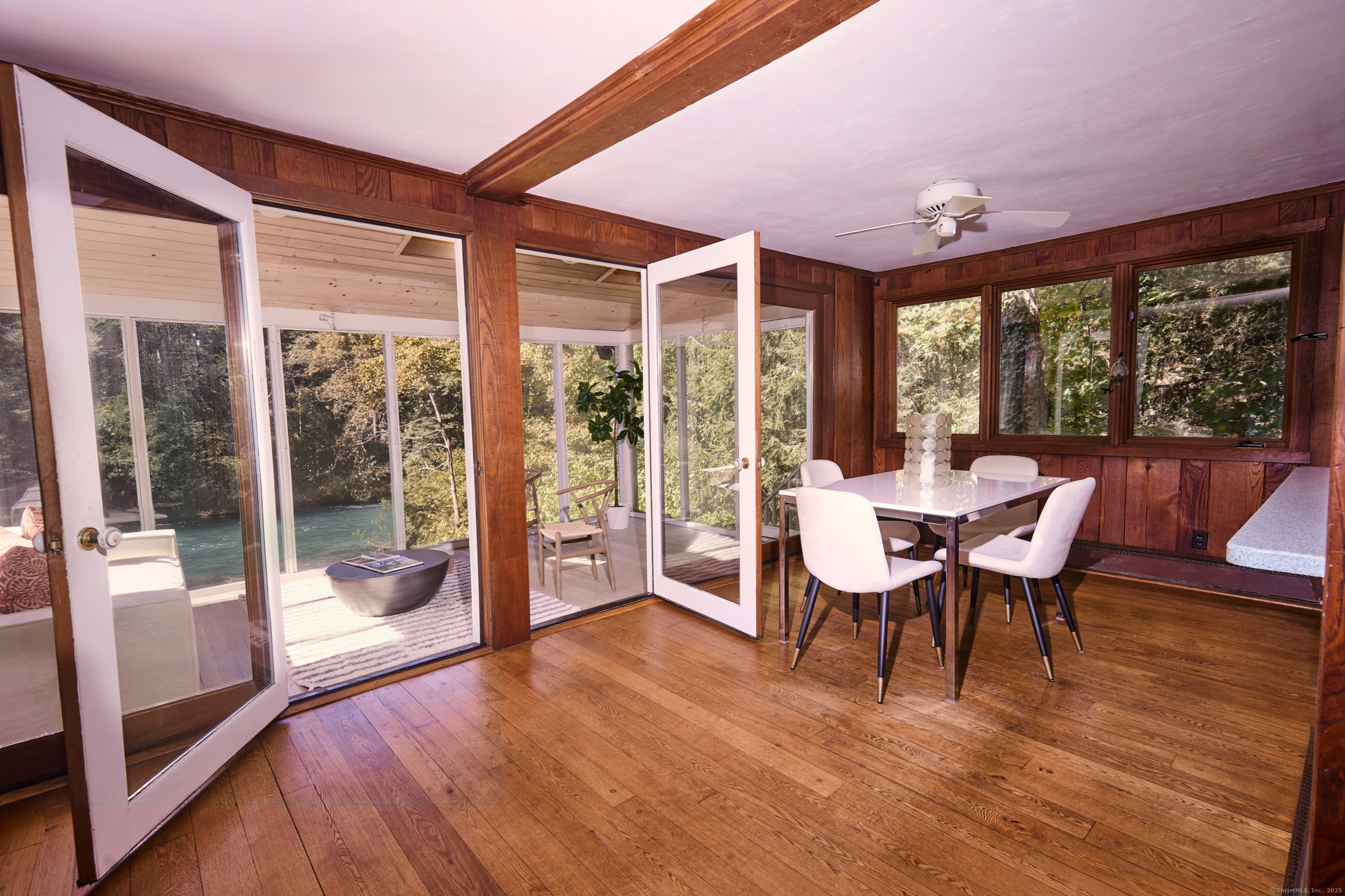 136 Lyons Plain Road Weston, CT 06883 - Photo 12 of 31 a dining room with wooden floor and large windows