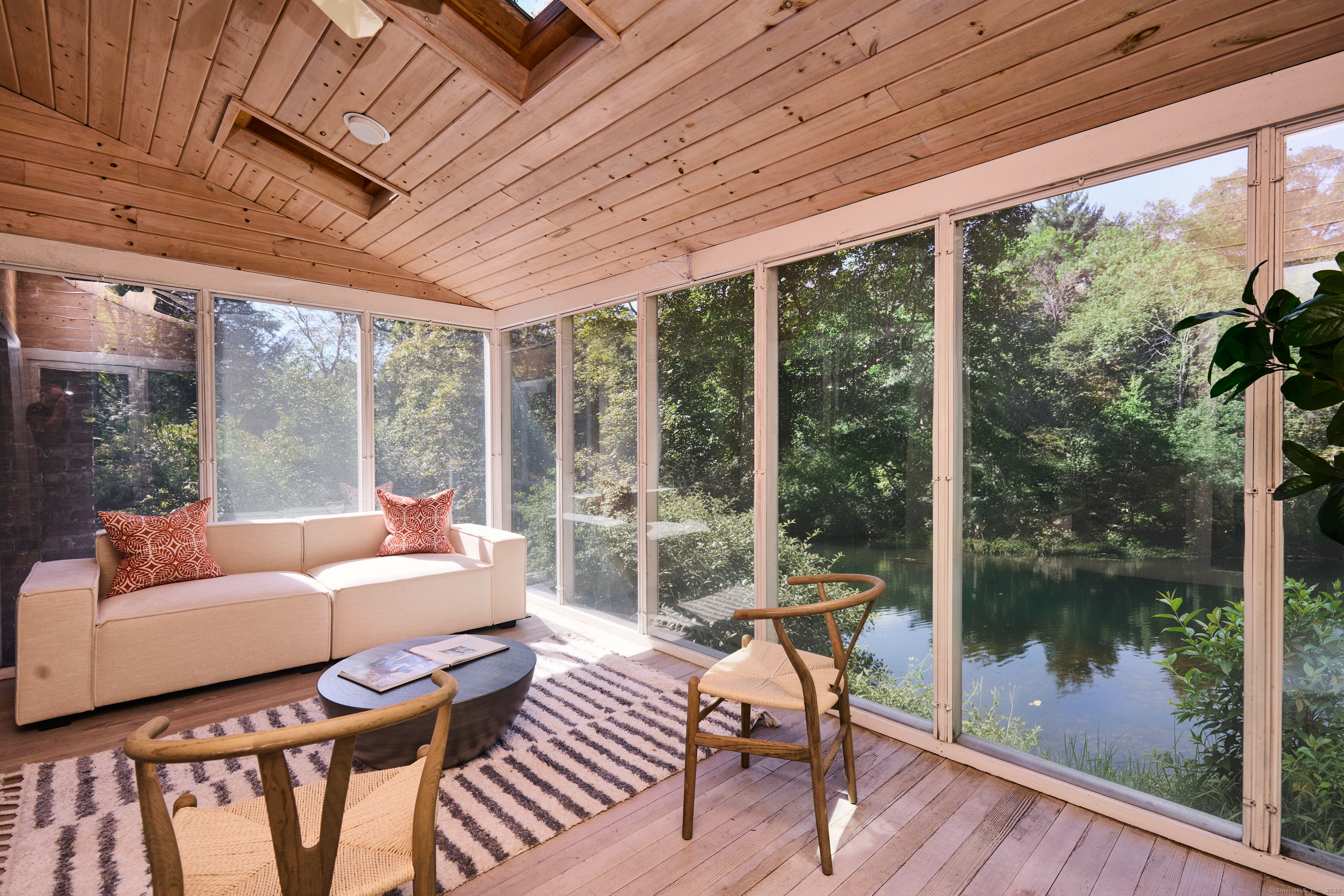 136 Lyons Plain Road Weston, CT 06883 - Photo 13 of 31 a living room with patio furniture and a floor to ceiling window