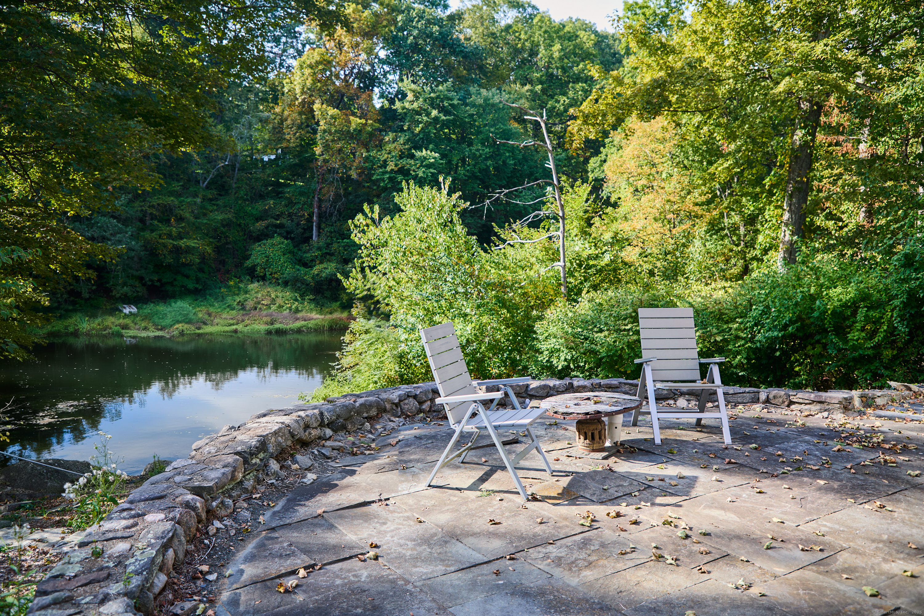136 Lyons Plain Road Weston, CT 06883 - Photo 20 of 31 a view of a patio with table and chairs and potted plants