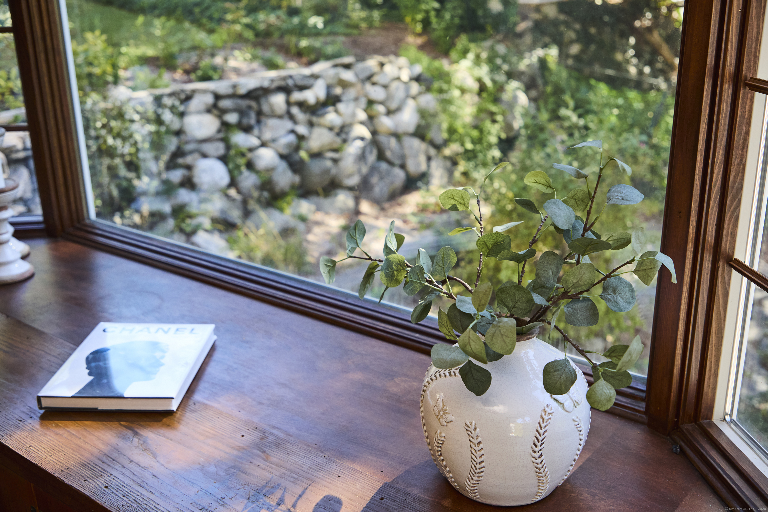 136 Lyons Plain Road Weston, CT 06883 - Photo 30 of 31 a vase of flowers sitting on a table with window
