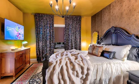 a bedroom with a bed and a chandelier
