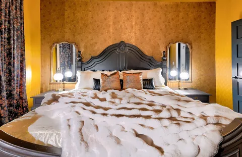 a bedroom with a bed and a dresser with mirror