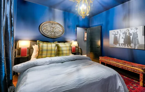 a bedroom with a bed and a lamp on dresser