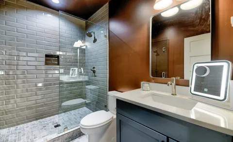 a bathroom with a double vanity sink toilet and mirror