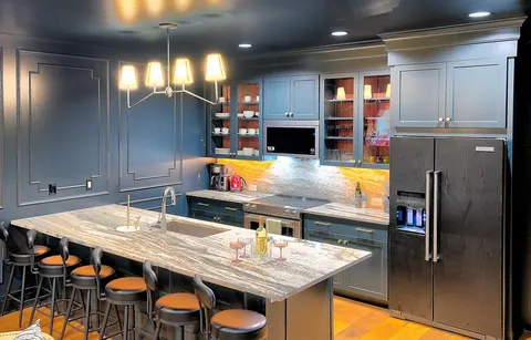 a kitchen with stainless steel appliances kitchen island granite countertop a table chairs and a refrigerator