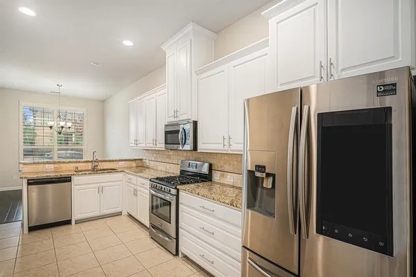 a kitchen with stainless steel appliances a refrigerator sink and cabinets