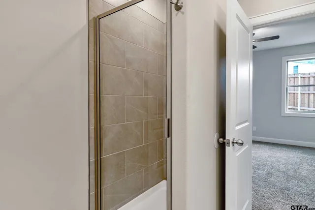 an empty room with a window and a fan