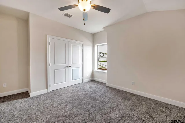 an empty room with a window and a fan