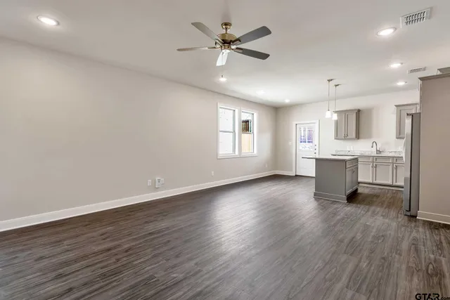 a view of a kitchen with a sink and dishwasher a refrigerator with wooden floor