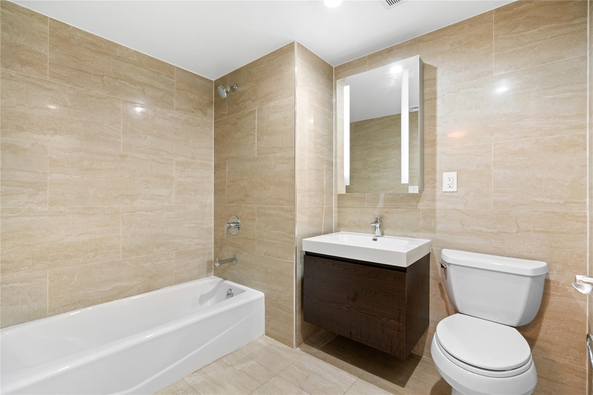 9745 63rd Drive, Unit 7A Queens, NY 11374 - Photo 13 of 20 a bathroom with a sink a toilet and shower