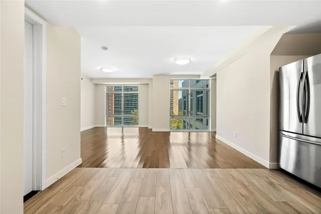 a view of a kitchen with wooden floor and a refrigerator
