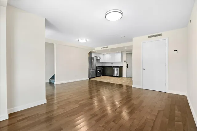 a view of empty room with wooden floor and fireplace