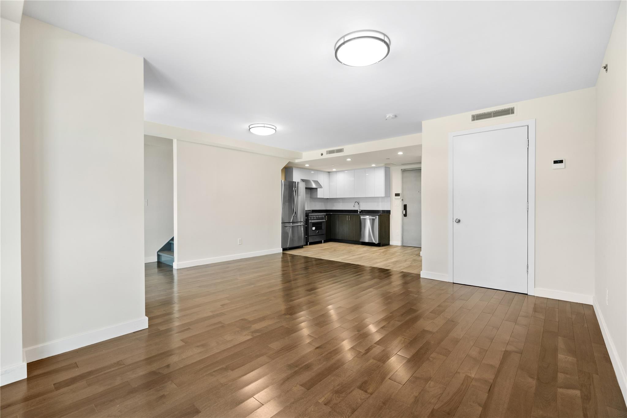 9745 63rd Drive, Unit 7A Queens, NY 11374 - Photo 4 of 20 a view of empty room with wooden floor and fireplace