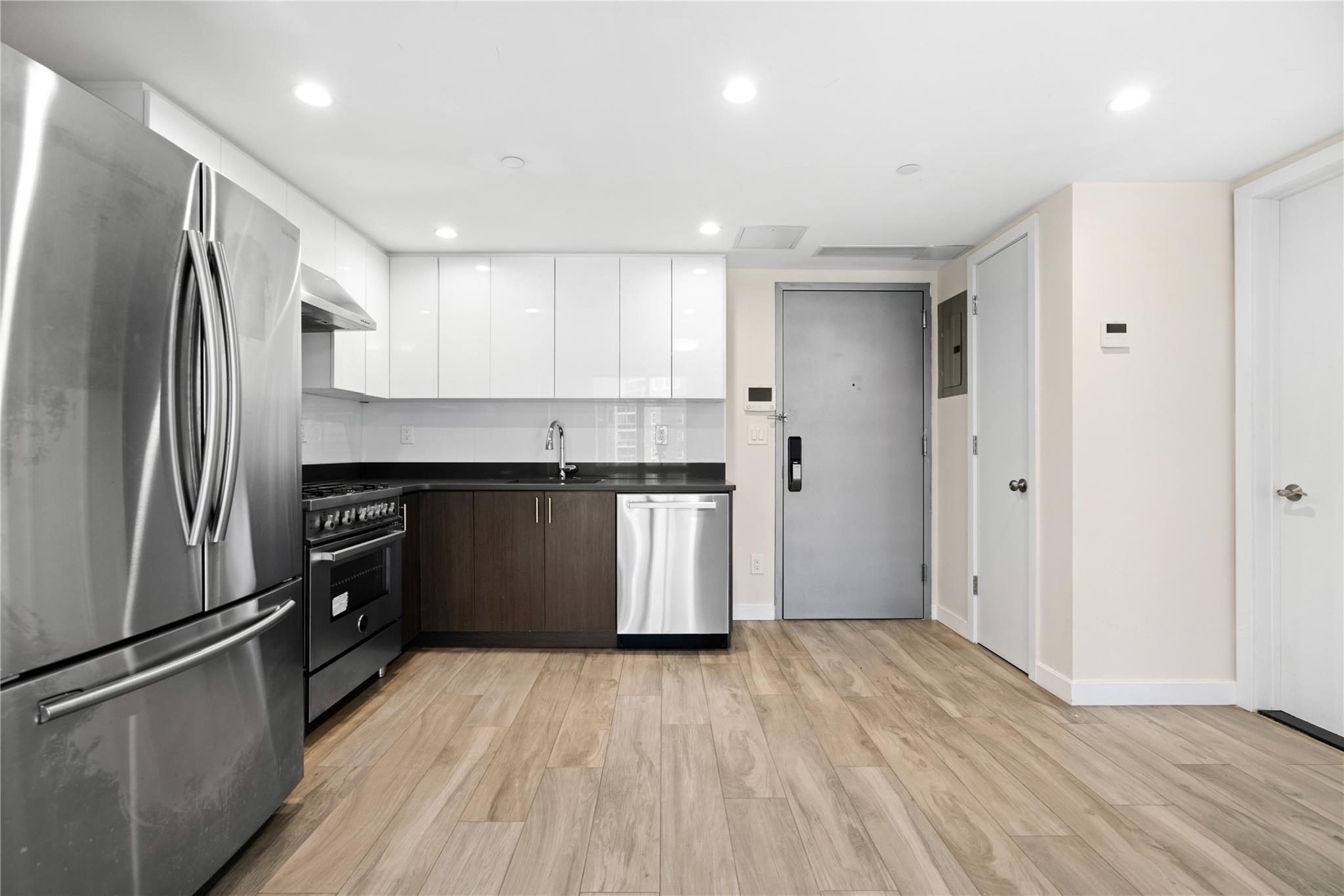 9745 63rd Drive, Unit 7A Queens, NY 11374 - Photo 6 of 20 a kitchen with a refrigerator and a sink