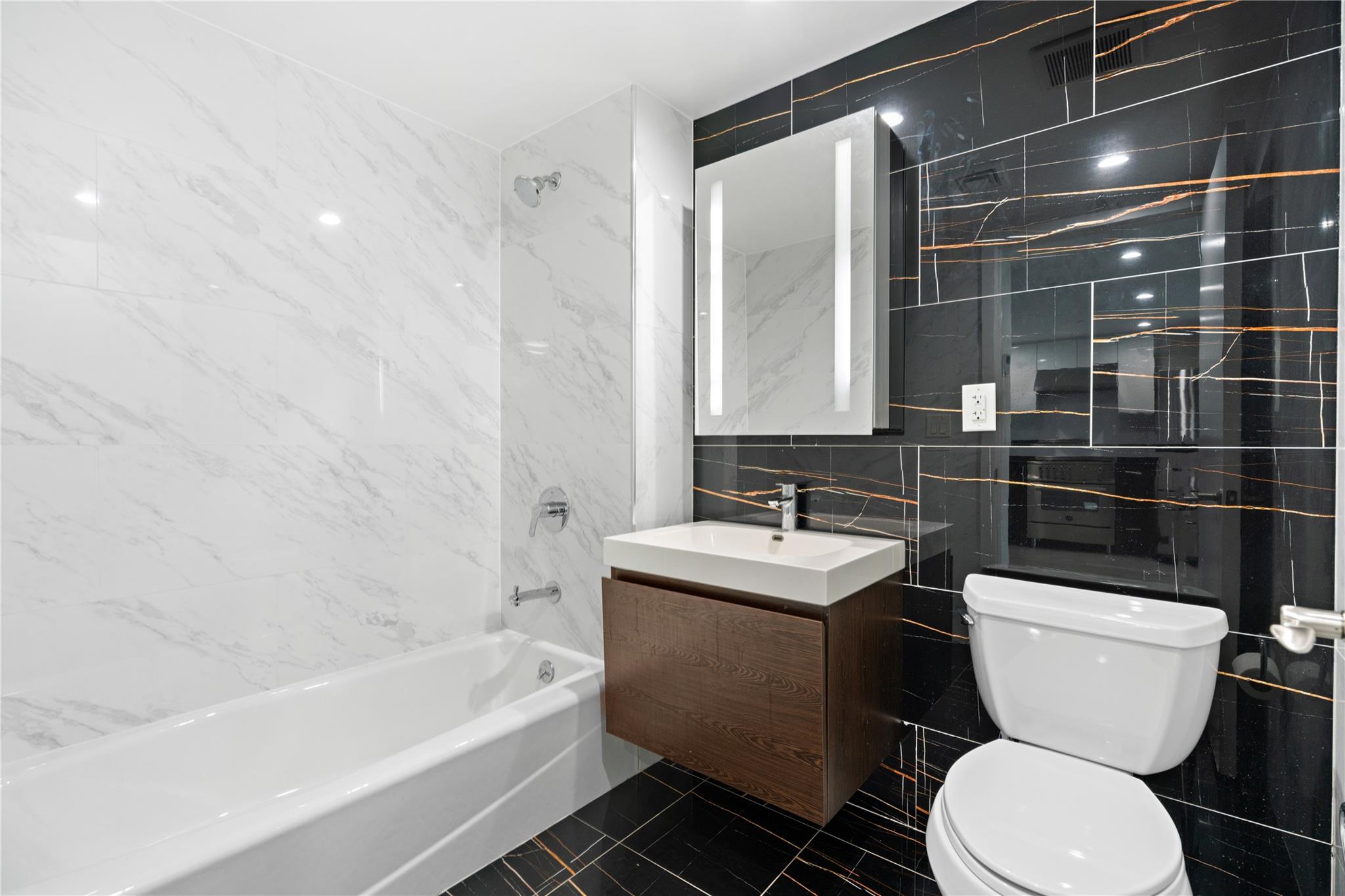 9745 63rd Drive, Unit 7A Queens, NY 11374 - Photo 8 of 20 a bathroom with a toilet a sink and bathtub