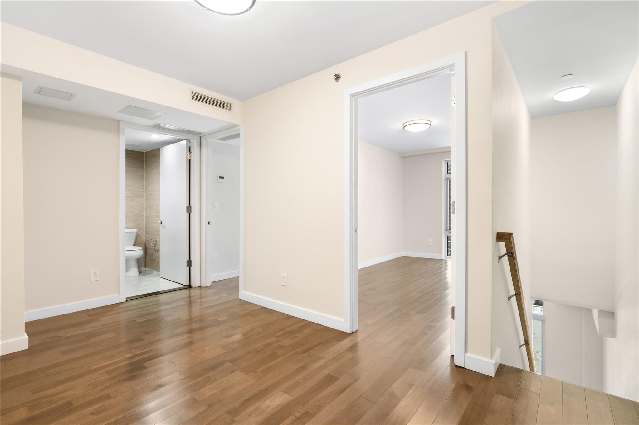 9745 63rd Drive, Unit 7A Queens, NY 11374 - Photo 9 of 20 an empty room with wooden floor and entrance