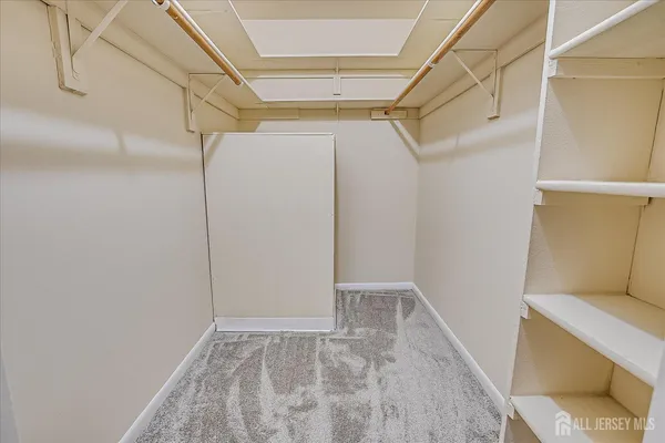 a view of walk in closet with empty racks