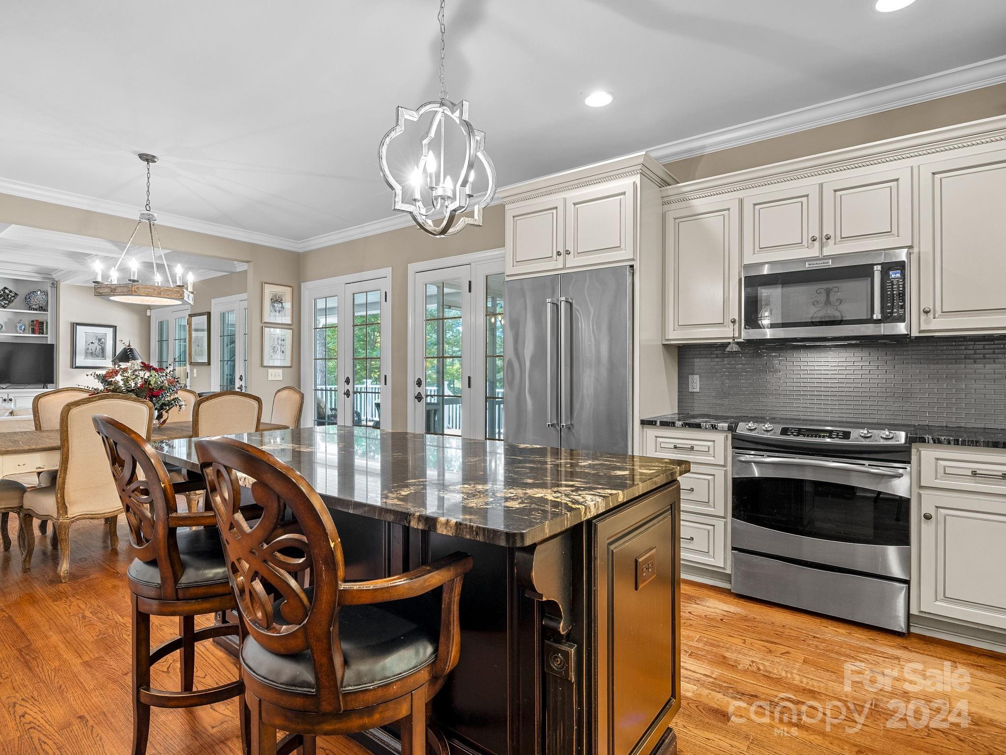699 Bill Collins Road Columbus, NC 28722 - Photo 13 of 38 a view of a dining room with furniture a chandelier and kitchen view