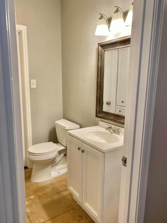 4404 Travis Country Circle, Unit G4 Austin, TX 78735 - Photo 8 of 15 A well-lit powder room showcases a bright white vanity and toilet, ready for guest use.