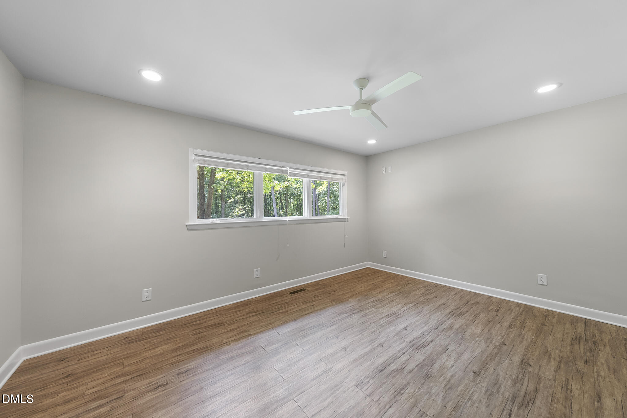 1605 Ridge Road Raleigh, NC 27607 - Photo 28 of 34 an empty room with wooden floor chandelier fan and windows