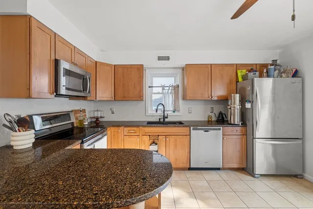 a kitchen with stainless steel appliances granite countertop a refrigerator sink and stove