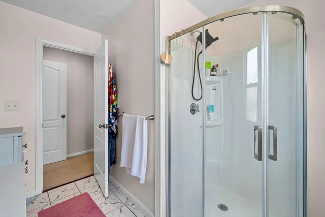 a bathroom with a glass shower door and a glass door