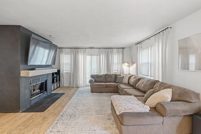 a living room with furniture a fireplace and a flat screen tv