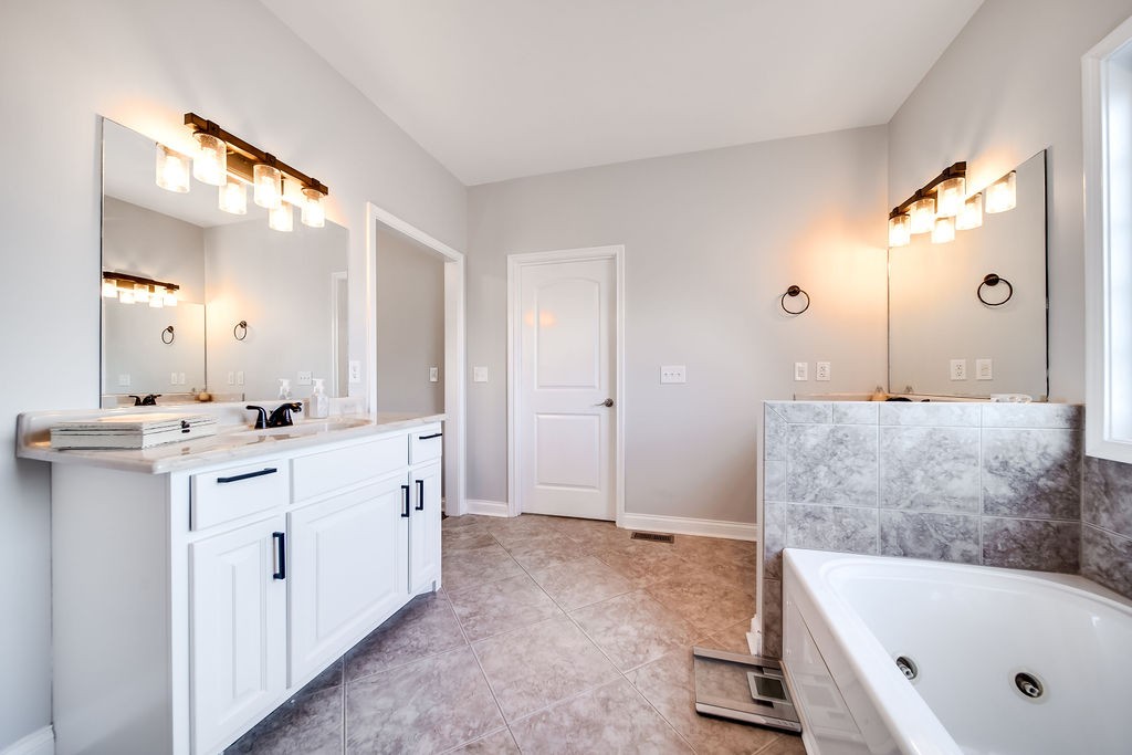4945 Charles Dorris Road Springfield, TN 37172 - Photo 26 of 41 a bathroom with a tub a double vanity sink and mirror