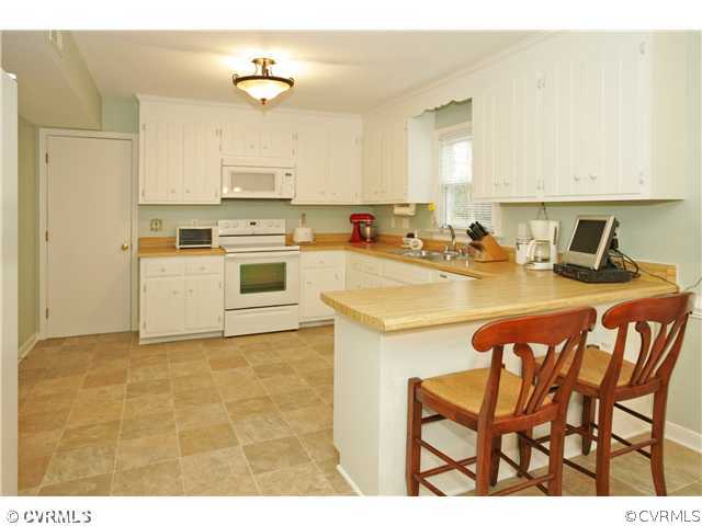 5703 Oak Knoll Road Midlothian, VA 23112 - Photo 2 of 12 a kitchen with a stove a sink cabinets and a refrigerator